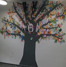 Ein Baum als Wandbild, mit bunten Händen als Blätter